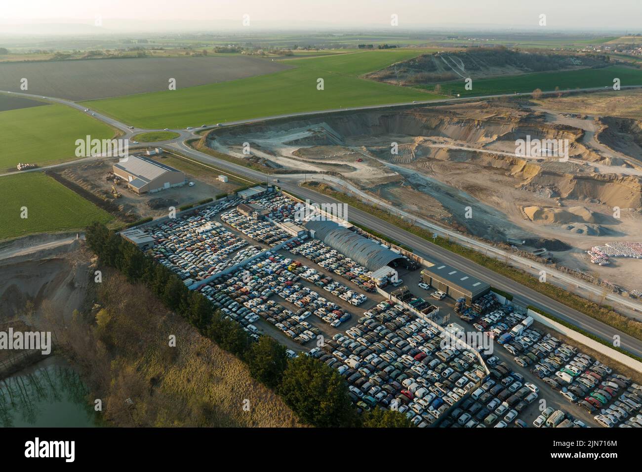 Luftaufnahme des großen Parkplatzes von Schrottplatz mit Reihen von weggeworfenen gebrochenen Autos. Recycling von Altfahrzeugen Stockfoto