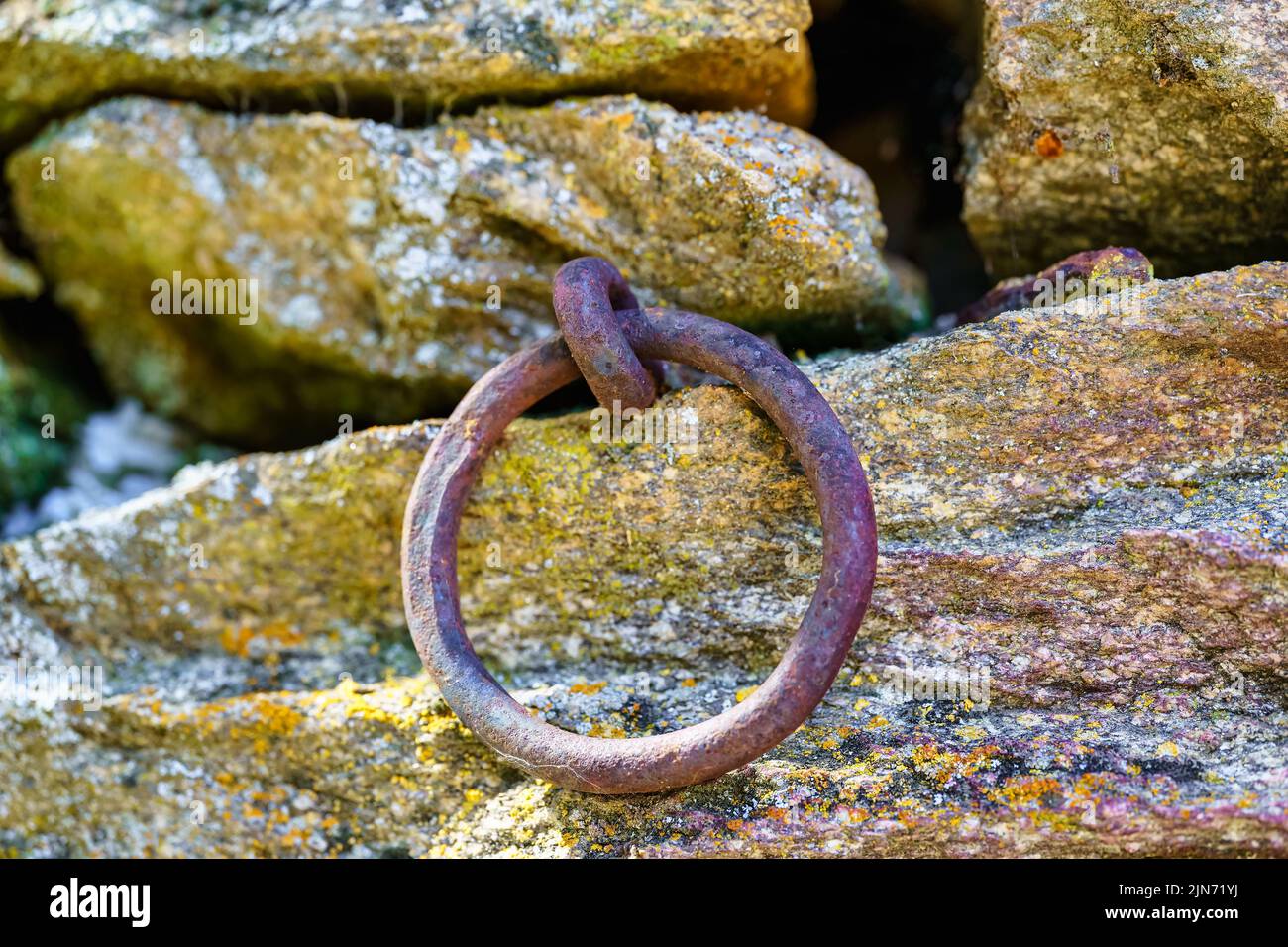 Gusseiserner Ring im Granitdamm zum Festmachen von Schiffen. Stockfoto