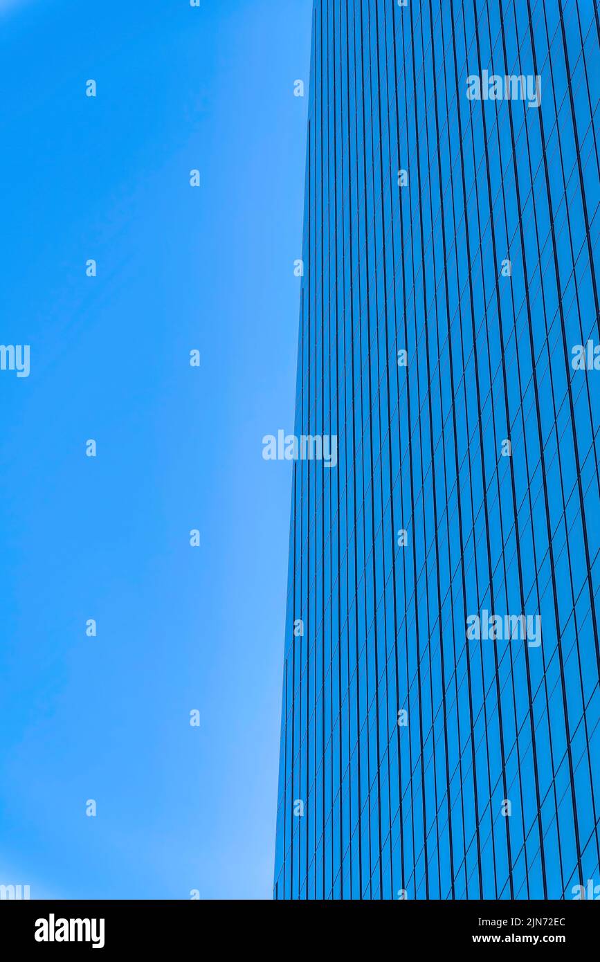 Wolkenkratzer mit einer Spiegelung des Himmels an den Glaswänden - Austin, Texas. Hohes mehrstöckiges Gebäude auf der rechten Seite und klarer Himmel Stockfoto