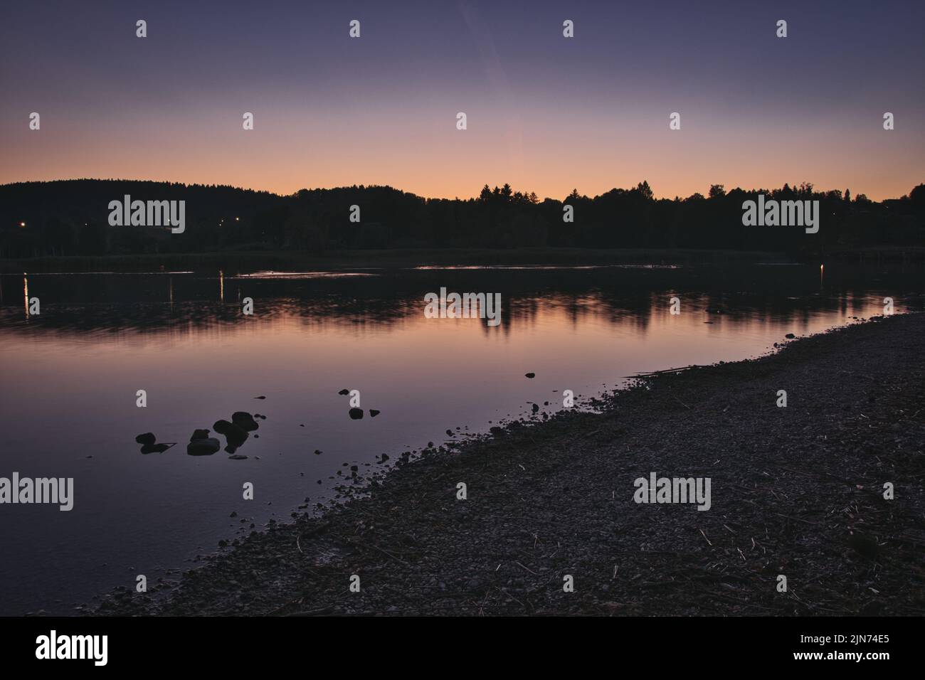 Der See mit der Spiegelung von Bergen und Lichtern auf der Wasseroberfläche in Gmund am Tegernsee, Bayern, Deutschland Stockfoto