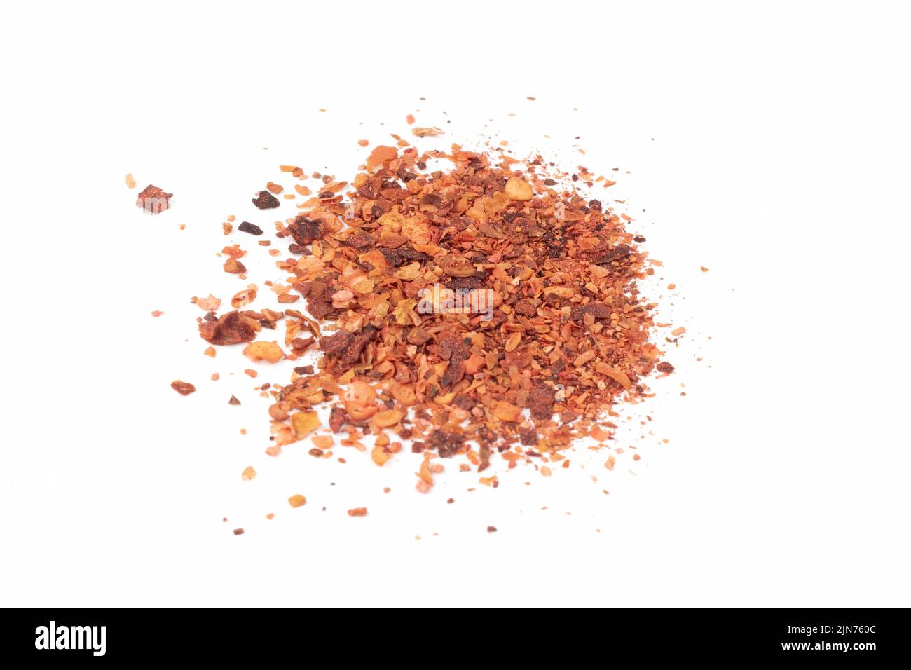 Zerkleinerte rote Cayennepfeffer. Pile zerkleinerten roten Cayennepfeffer, getrocknete Chili-Flocken und Samen auf hellem Hintergrund isoliert. Nahaufnahme. Stockfoto
