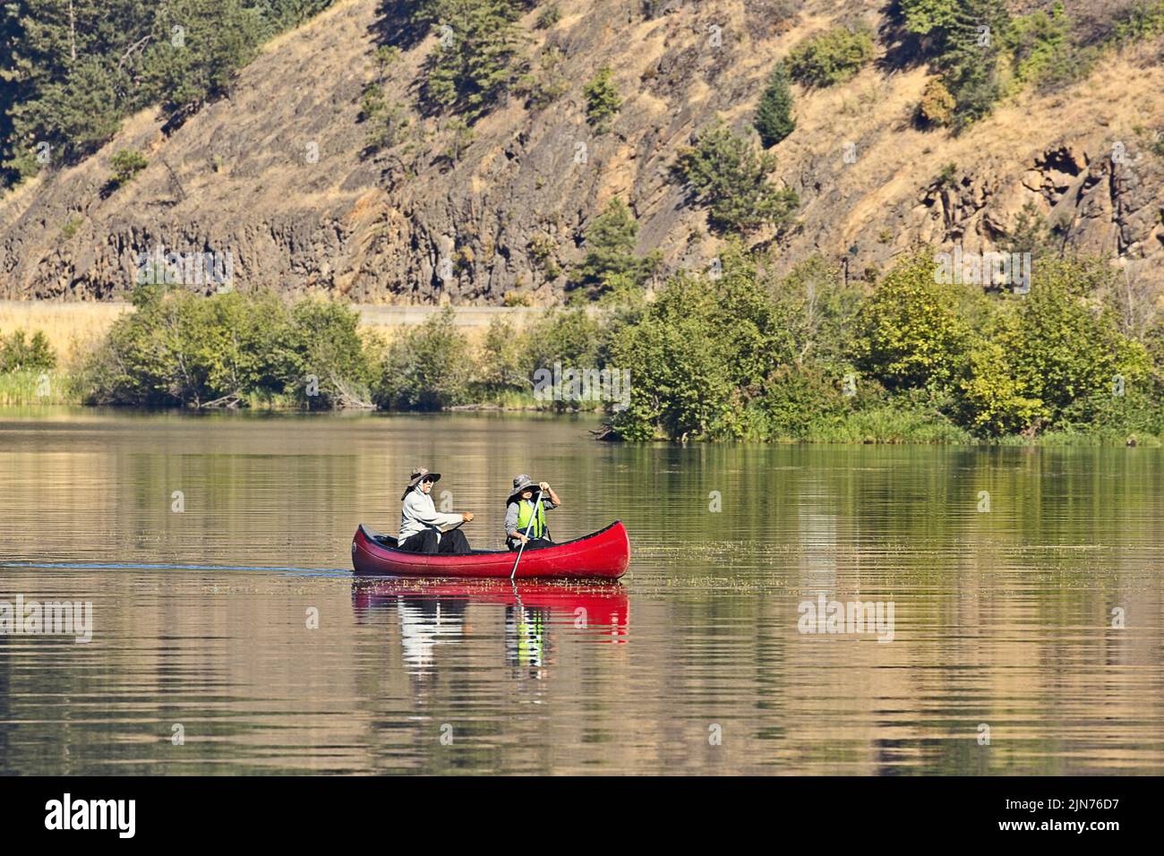 Ein redaktionelles Foto eines reifen Paares, das auf dem Coeur d'Alene Lake im Norden von Idaho mit dem Kanu paddelt. Stockfoto
