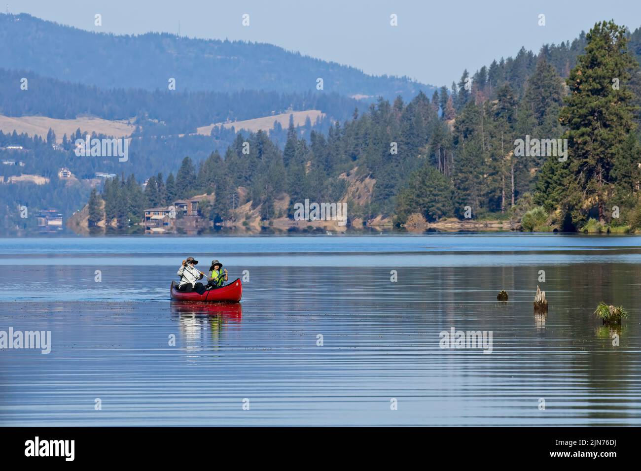 Ein redaktionelles Foto eines reifen Paares, das auf dem Coeur d'Alene Lake im Norden von Idaho mit dem Kanu paddelt. Stockfoto