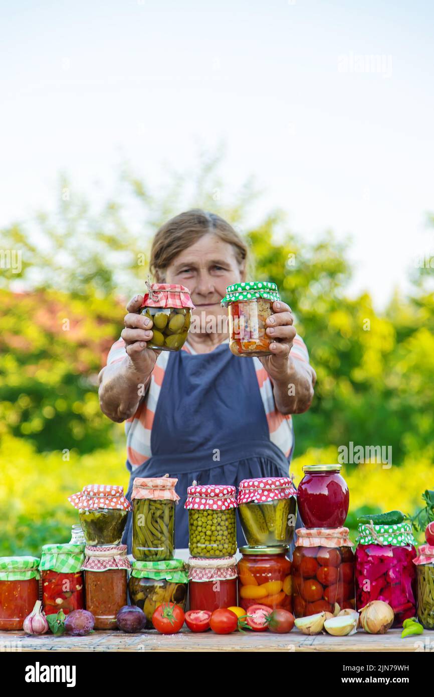 Ältere Frau, die Gemüse in Gläsern konservieren. Selektiver Fokus. Essen. Stockfoto