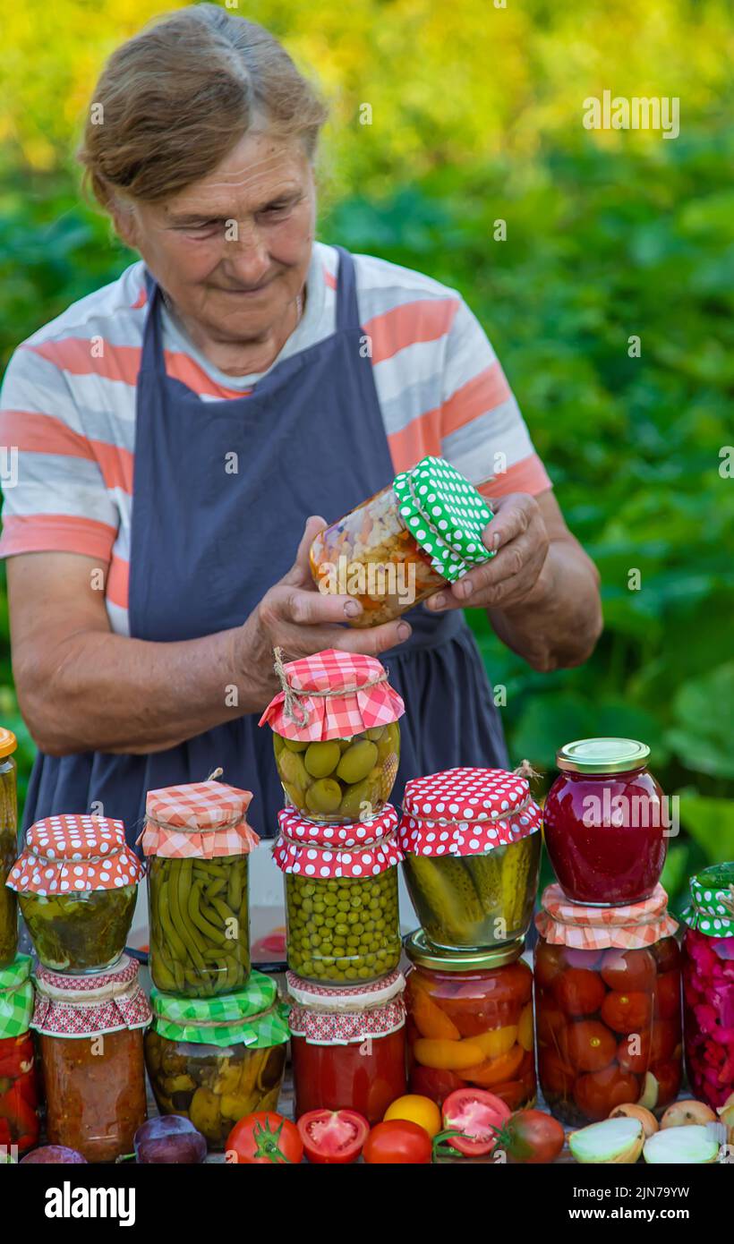 Ältere Frau, die Gemüse in Gläsern konservieren. Selektiver Fokus. Essen. Stockfoto