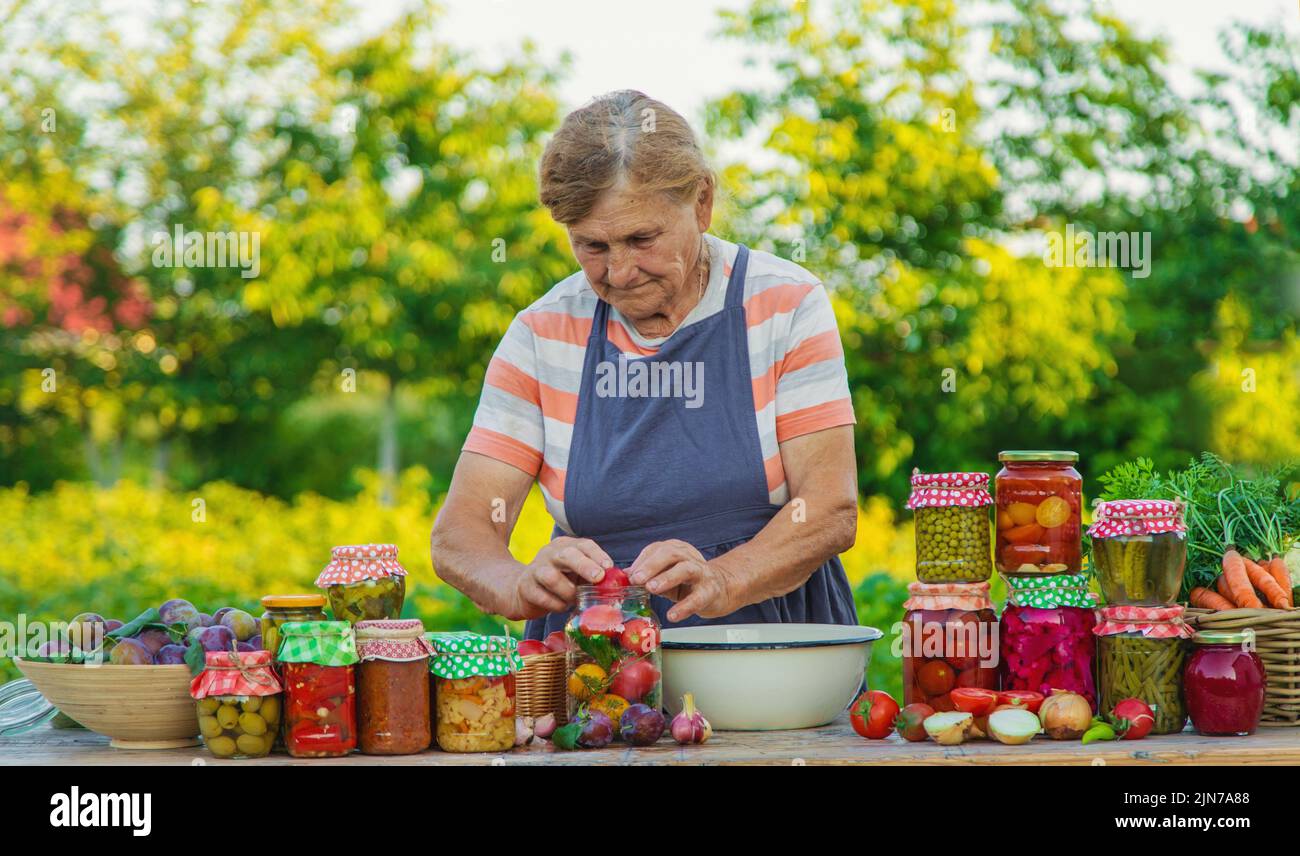 Ältere Frau, die Gemüse in Gläsern konservieren. Selektiver Fokus. Essen. Stockfoto