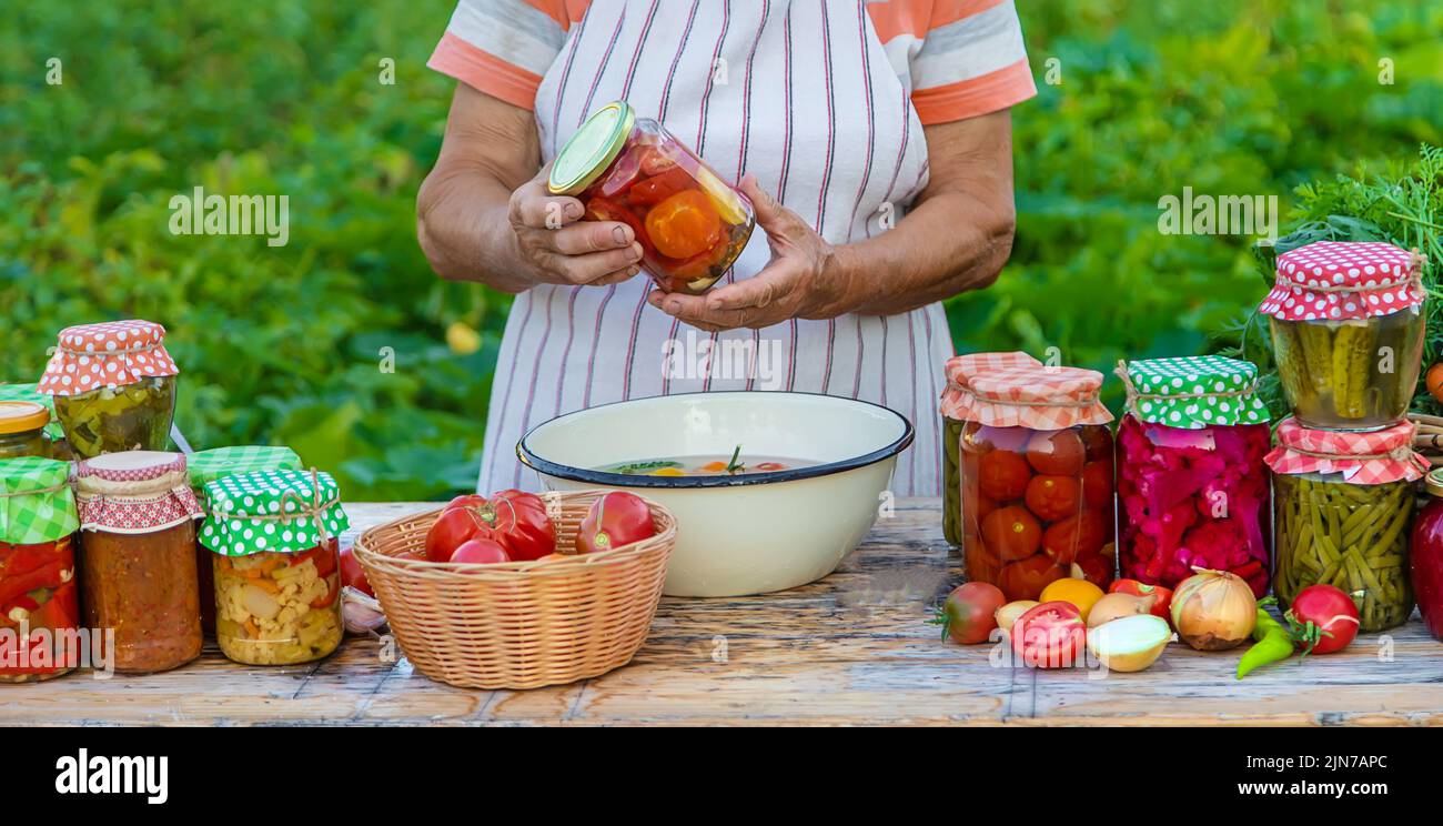 Ältere Frau, die Gemüse in Gläsern konservieren. Selektiver Fokus. Essen. Stockfoto