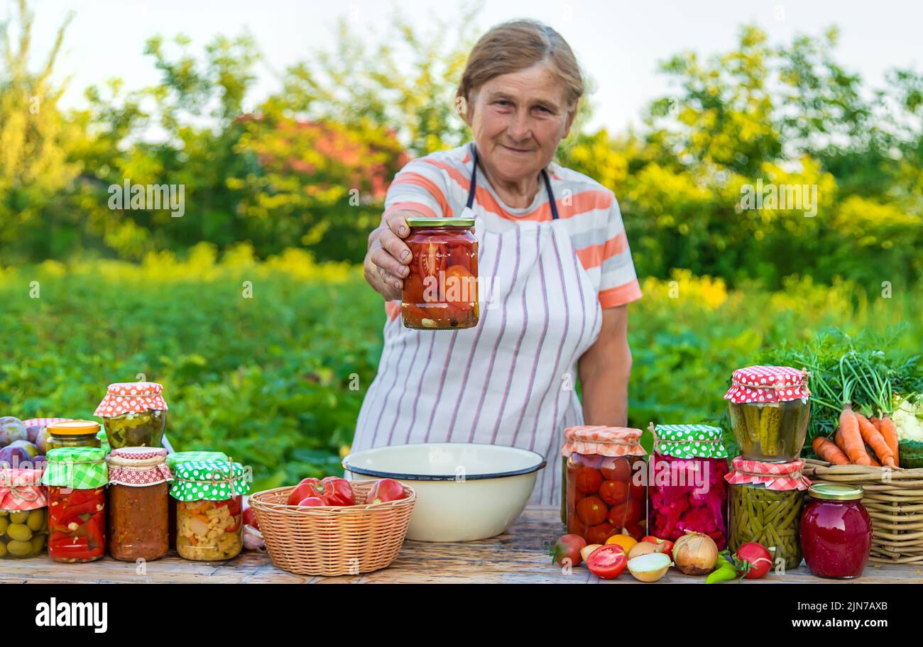 Ältere Frau, die Gemüse in Gläsern konservieren. Selektiver Fokus. Essen. Stockfoto