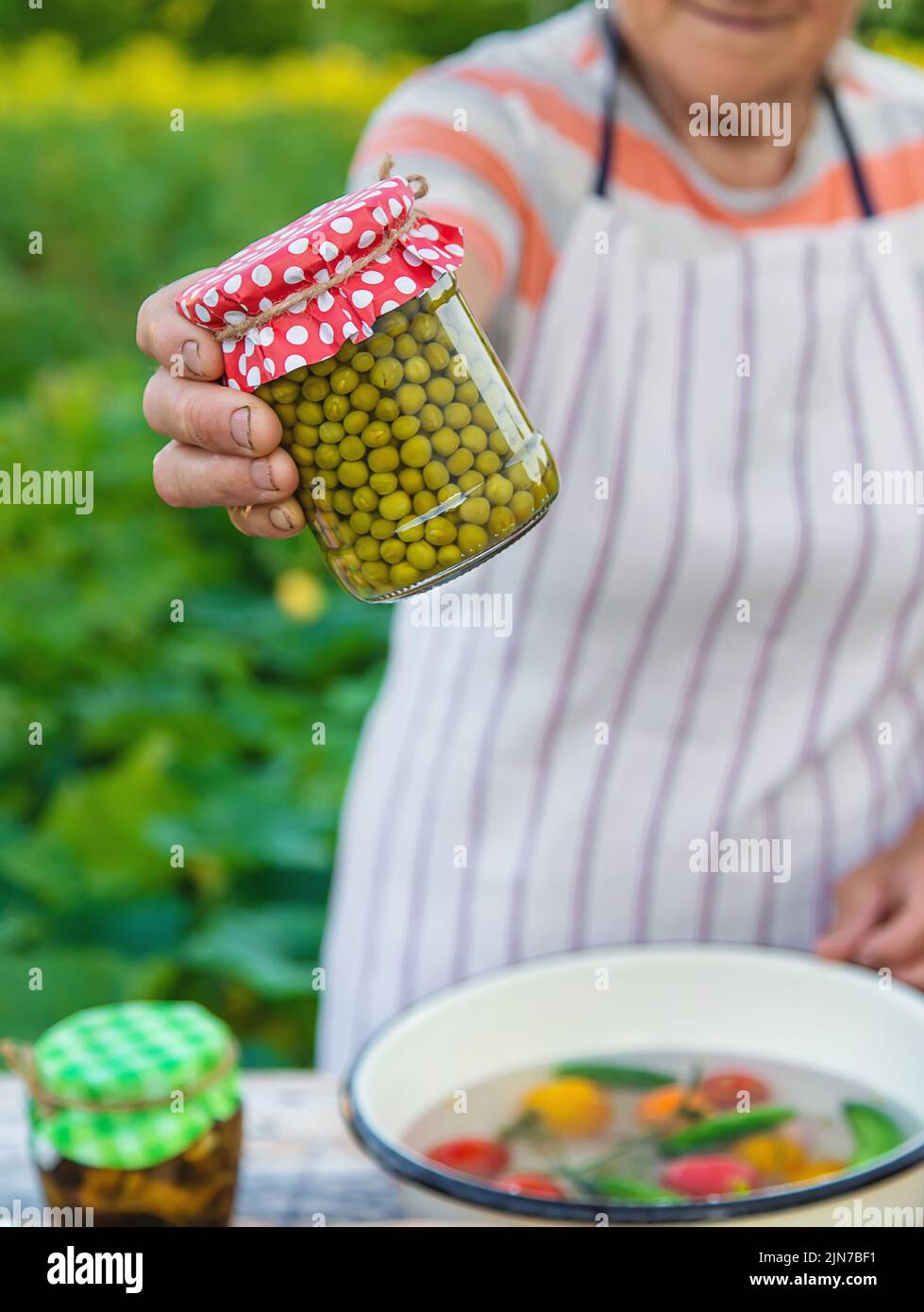 Ältere Frau, die Gemüse in Gläsern konservieren. Selektiver Fokus. Essen. Stockfoto