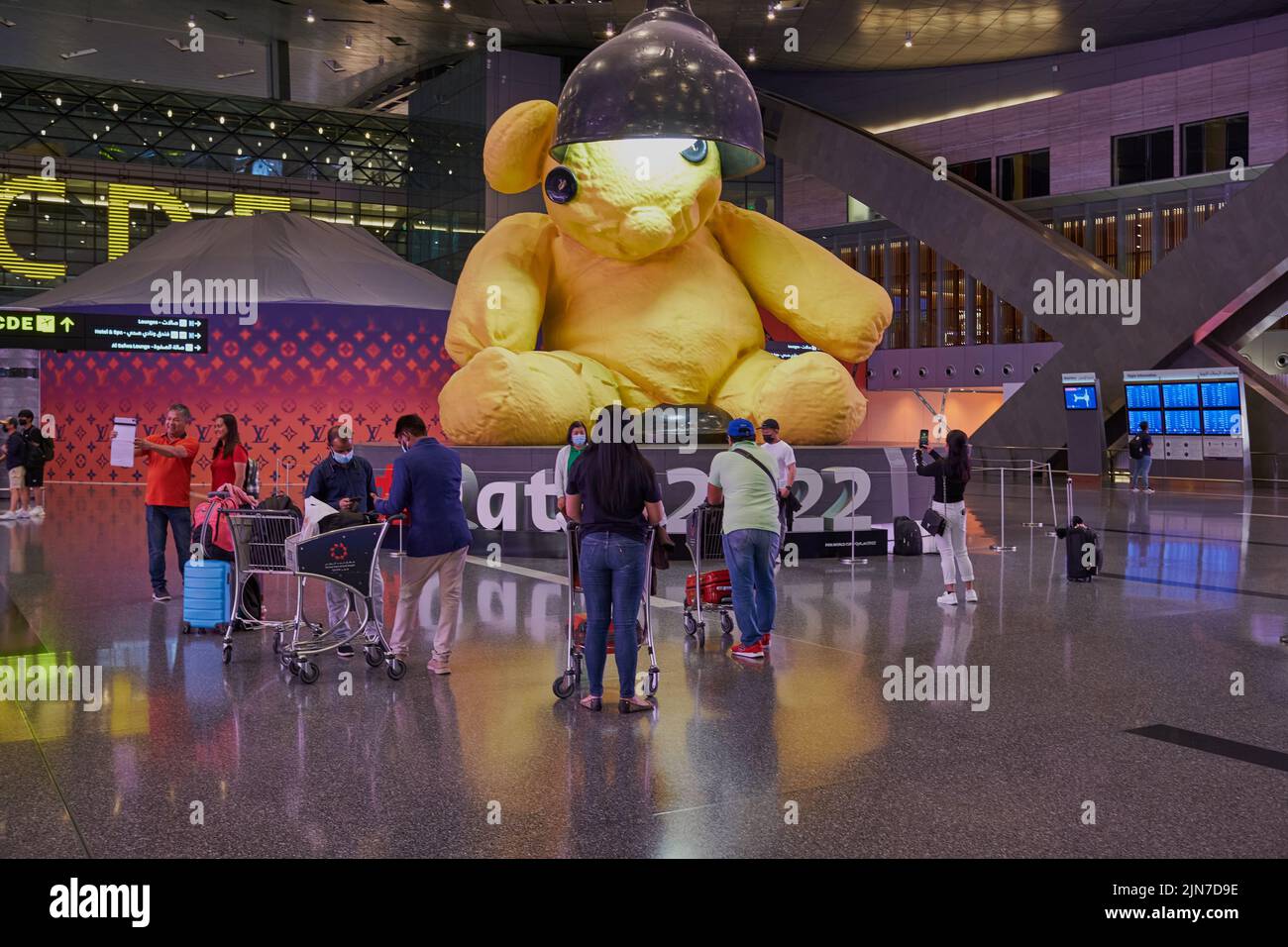 Abflughalle im Hamad International Airport, Doha, Katar bei Nacht mit der großen Lamp Bear Statue des Schweizer Künstlers Urs Fischer und # Qatar 2022 Stockfoto