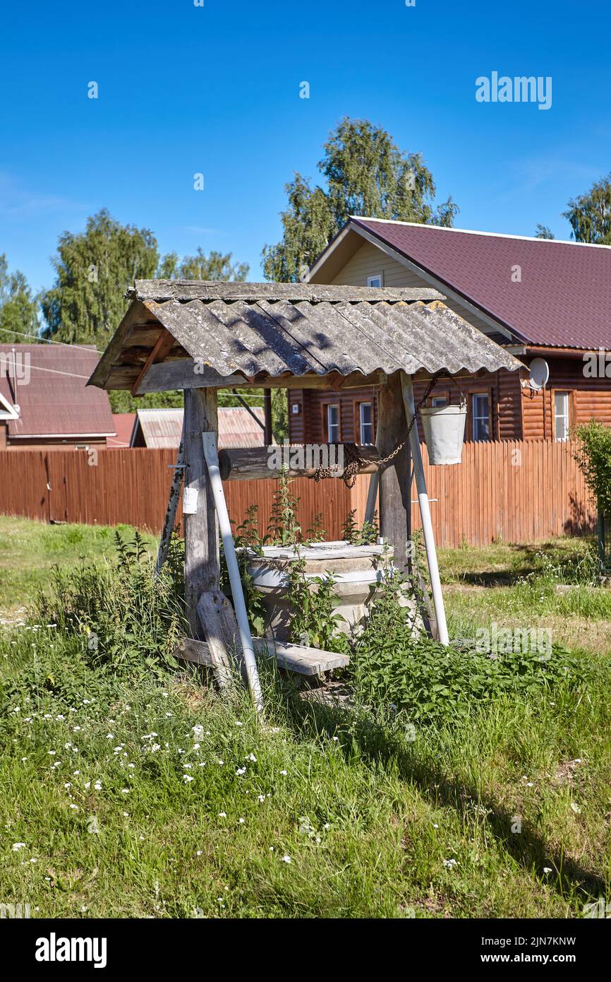 Traditioneller russischer alter Wasserbrunnen im Dorf. Ländliche Landschaft Stockfoto