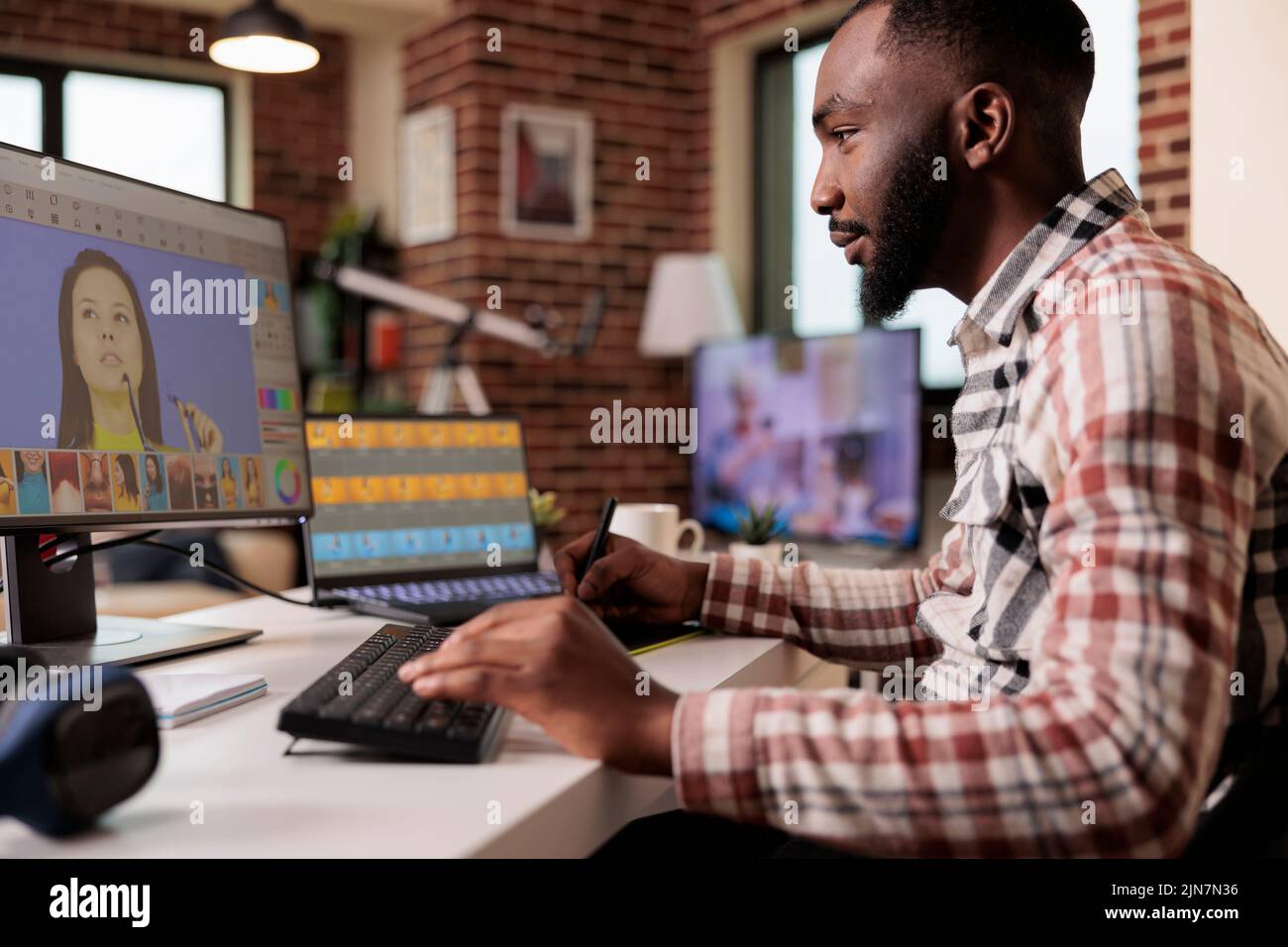 afroamerikanische Künstler retuschieren Bilder mit kreativer Software am Computer, arbeiten an der Bildproduktion. Freiberuflicher Editor Bearbeitung von Fotos mit Farbkorrektur, Retuschierprozess. Stockfoto