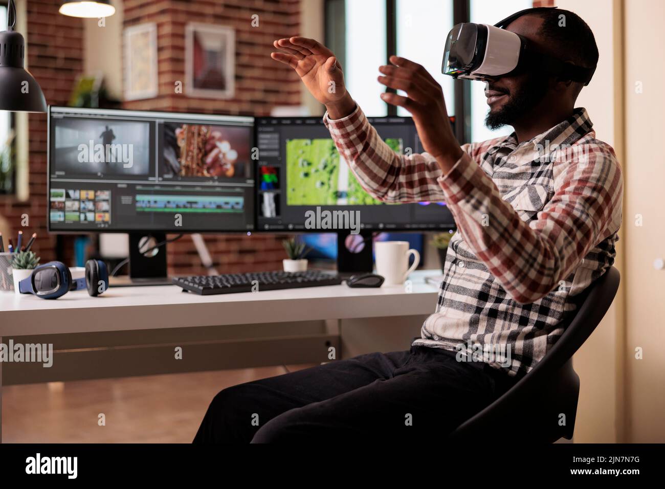 afroamerikanischer Filmemacher, der mit VR-Brillen arbeitet und Videomontage auf professioneller Postproduktions-Software bearbeitet. Videofilmer mit Augmented Reality-Brille zur Bearbeitung von Filmmaterial. Stockfoto