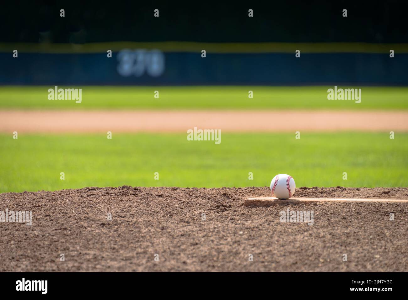 Nahaufnahme von Baseballspielen auf dem erhöhten Pitcher-Hügel auf einem Baseballfeld mit Regulierungsbestimmungen. Stockfoto