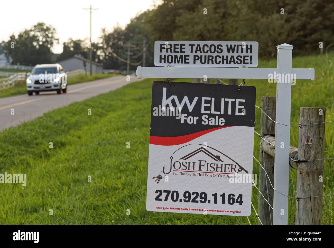 Utica, Kentucky, USA. 09 August 2022. Ein Fahrzeug fährt an einem Keller Williams Elite-Schild vorbei, auf dem „kostenlose Tacos beim Hauskauf!“ steht. Der amerikanische Wohnungsmarkt scheint sich in Richtung eines Gleichgewichts zu bewegen, so eine Analyse der Immobiliendaten des Juli durch die National Association of Realtors, Aber die medianen Abfragepreise liegen immer noch nahe am Allzeithoch, das im Juni 2022 festgelegt wurde, wobei die meisten Haushalte etwas schneller verkaufen als im Jahr 2021 und deutlich schneller als vor der COVID-19-Pandemie. (Kredit: Billy Suratt/Apex MediaWire über Alamy Live News) Stockfoto
