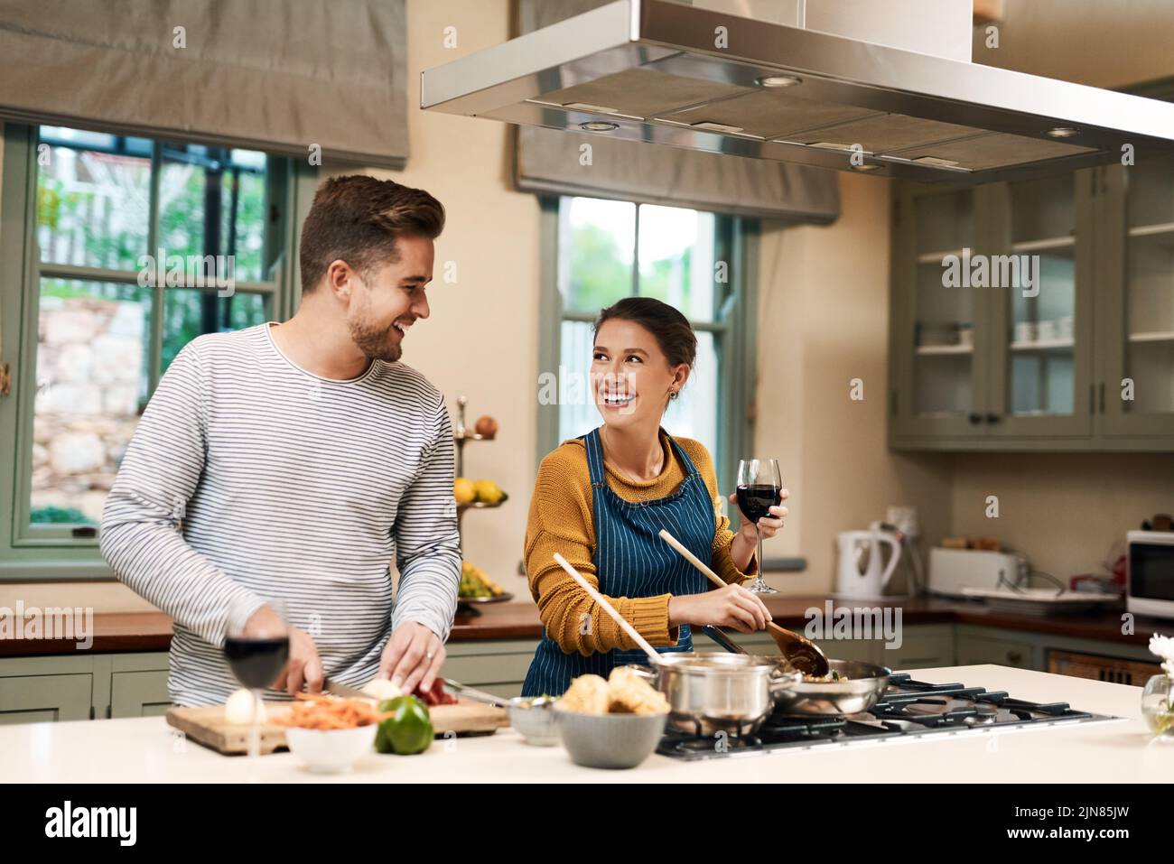 Es gibt keinen besseren Weg, sich zu verbinden. Ein liebevolles junges Paar kocht zusammen in ihrer Küche zu Hause. Stockfoto