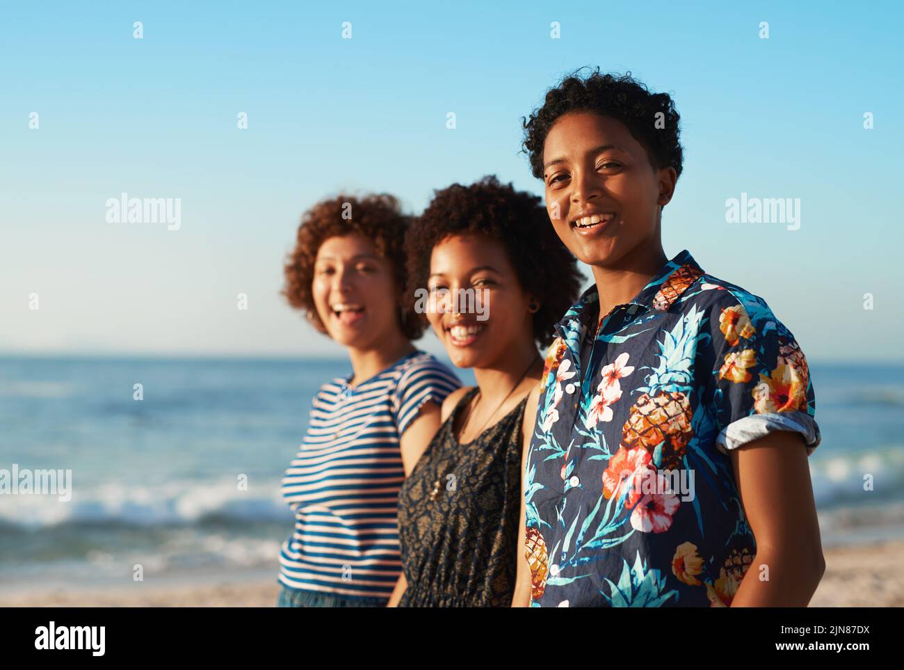 Wir werden uns immer wieder gegenseitig Rücken haben. Porträt von drei attraktiven jungen Frauen, die tagsüber zusammen stehen und am Strand posieren. Stockfoto