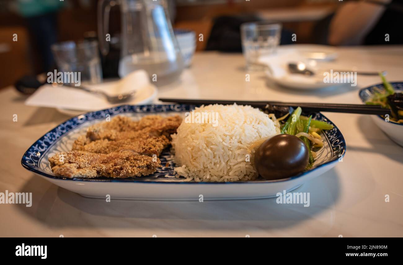 Asiatisches Essen auf einem Teller mit Reis. Verschiedene asiatische Gerichte im Restaurant, Blick von oben, Ort für Text. Asiatisches Speisekonzept. Niemand. Stockfoto