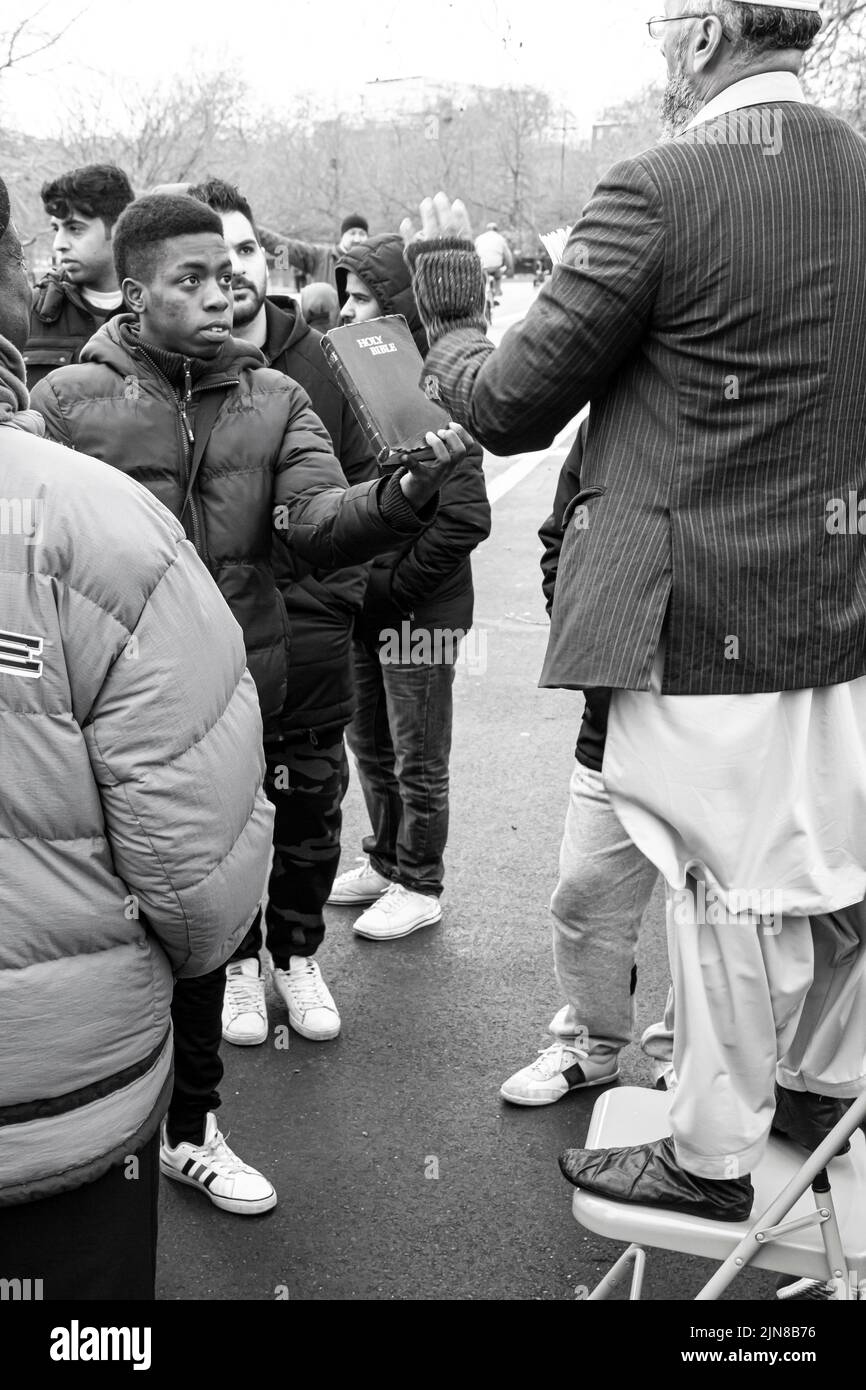 Graustufen-Aufnahme von Menschen in der Speakers Corner in Marble Arch London, berühmt für Redefreiheit und Debattierfreiheit. Die Hände der Religion Stockfoto