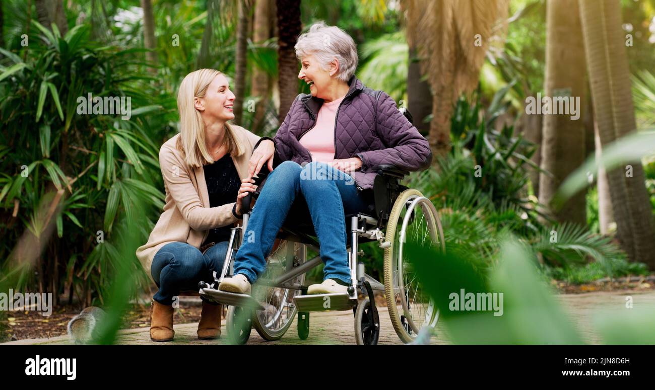 Vielen Dank, dass Sie hier sind Liebe. Eine fröhliche ältere Frau im Rollstuhl verbringt Zeit mit ihrer Tochter draußen in einem Park. Stockfoto