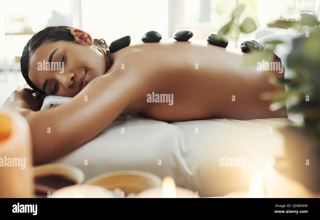 Dies ist die entspannendste Behandlung. Eine junge Frau bekommt eine Hot-Stone-Massage in einem Spa. Stockfoto