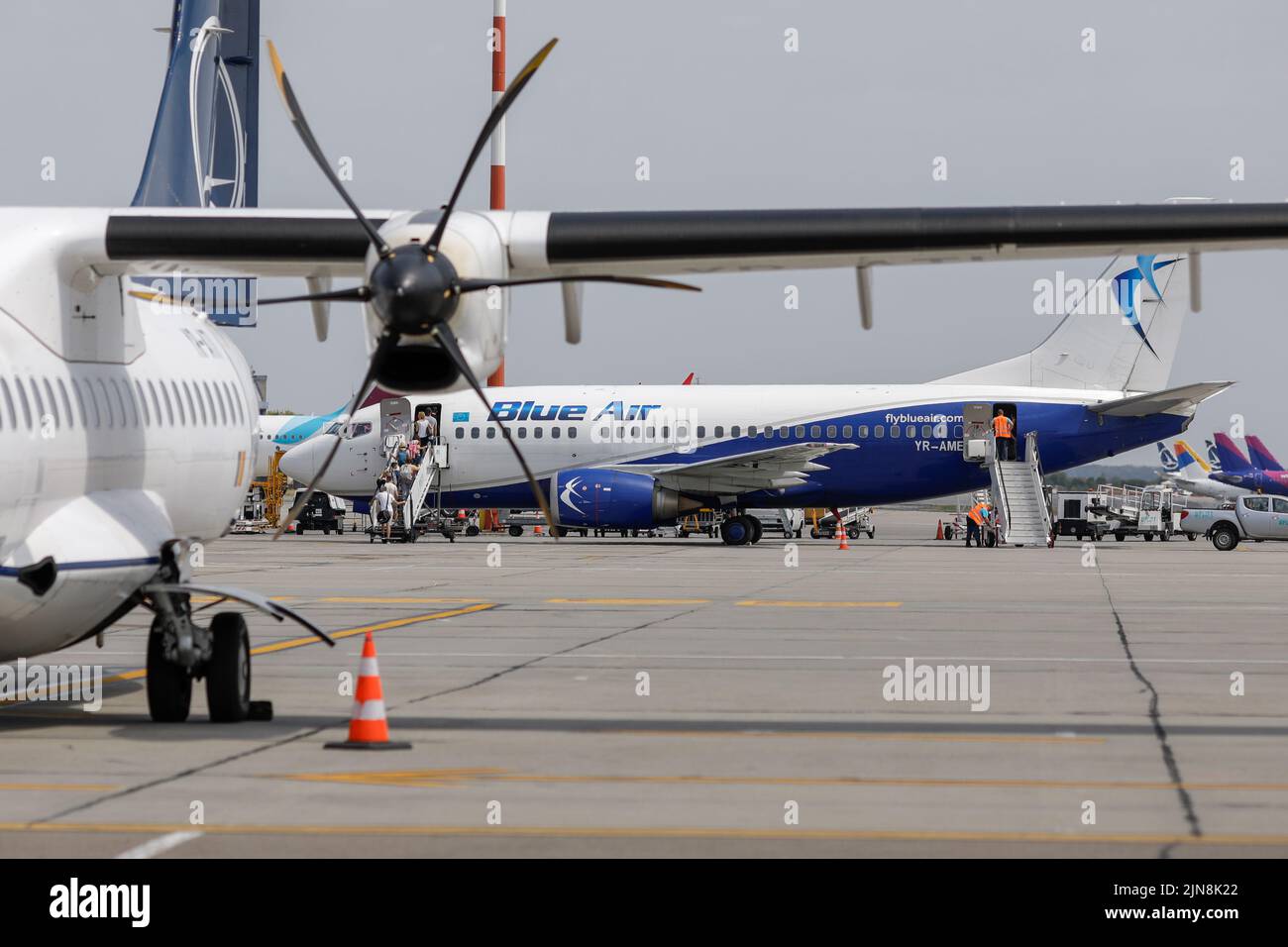Otopeni, Rumänien - 9. August 2022: Passagiere steigen am Henri Coanda International Airport in ein Blue Air-Flugzeug ein. Stockfoto