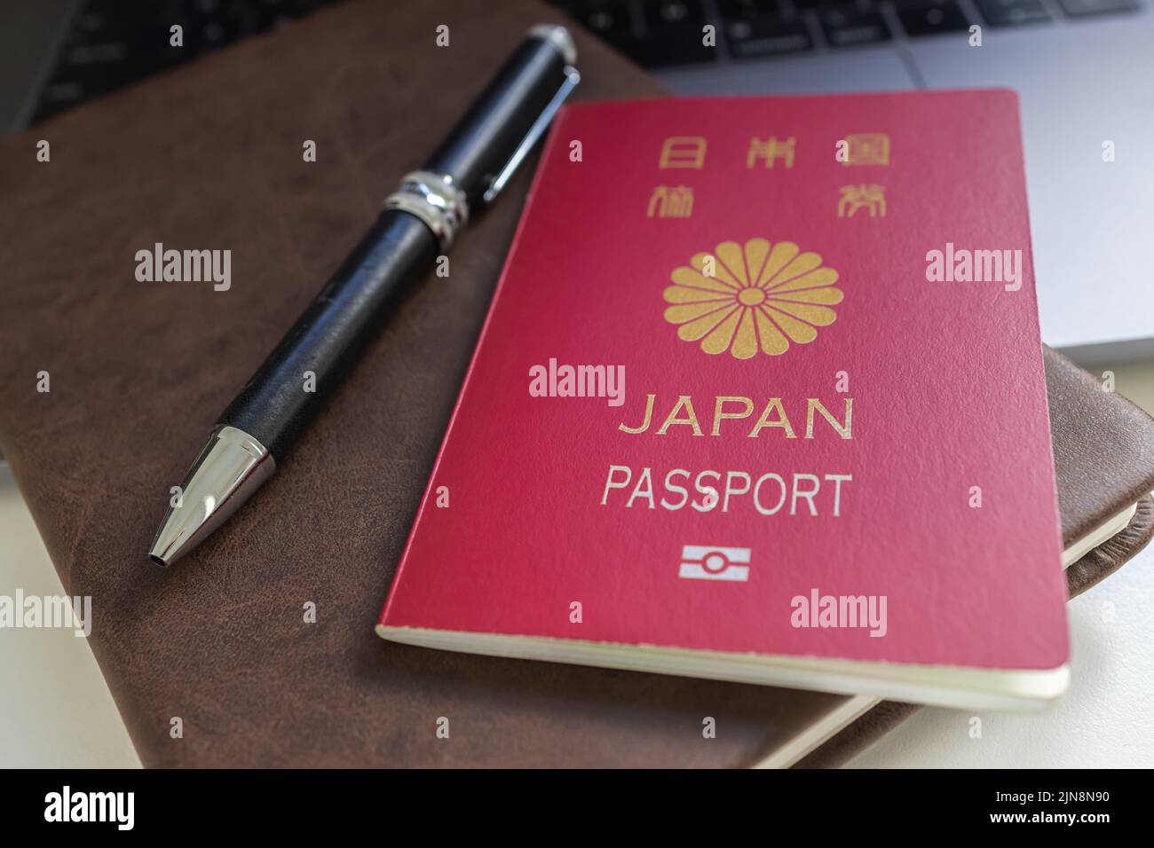 Ein japanischer Reisepass, ein Vintage-Notizbuch und ein Stift, das Konzept der Auslandsreise Stockfoto