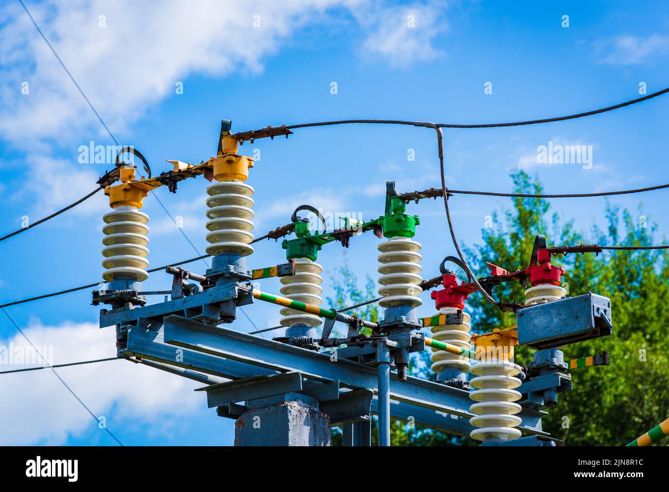 Elektrische Stromübertragungsleitungen.Hochspannungs-Schaltanlage und Ausrüstung des Kraftwerks.Blauer Himmel weiß Wolken Sommertag. Stockfoto