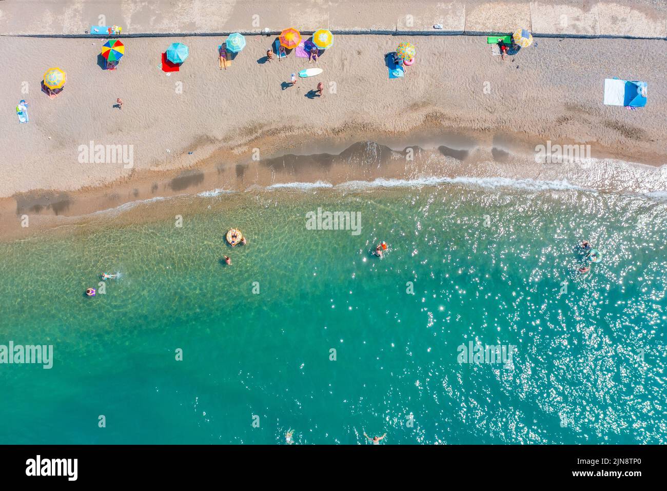 Wilder Strand mit einer kleinen Anzahl von Urlaubern, die an der Meeresküste schwimmen, Luftaufnahme Stockfoto