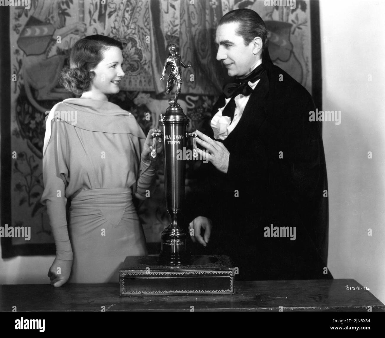 BELA LUGOSI in Kostüm als Graf Mora zeigt Co-Star ELIZABETH ALLAN seine Bela Lugosi Fußball / Football Trophy am Set offen während der Dreharbeiten von MARK OF THE VAMPIRE 1935 Regisseur Tod BROWNING Metro Goldwyn Mayer Stockfoto