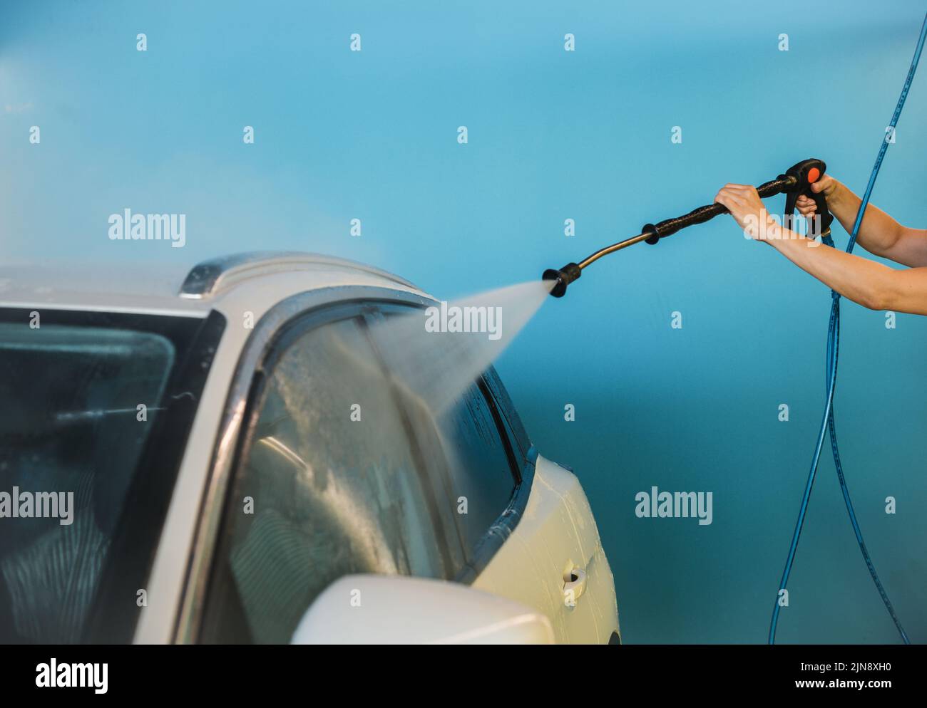 Crop Frau waschen Fenster des Autos Stockfoto
