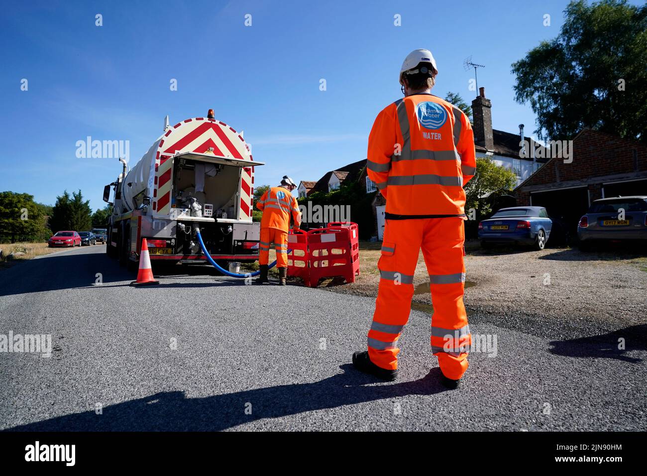 Arbeiter von Thames Water liefern eine temporäre Wasserversorgung von einem Tanker in das Dorf Northend in Oxfordshire, wo das Wasserunternehmen nach einem technischen Problem im Stokenchurch Reservoir in Oxfordshire Wasser in das Versorgungsnetz pumpt. TBilddatum: Mittwoch, 10. August 2022. Stockfoto