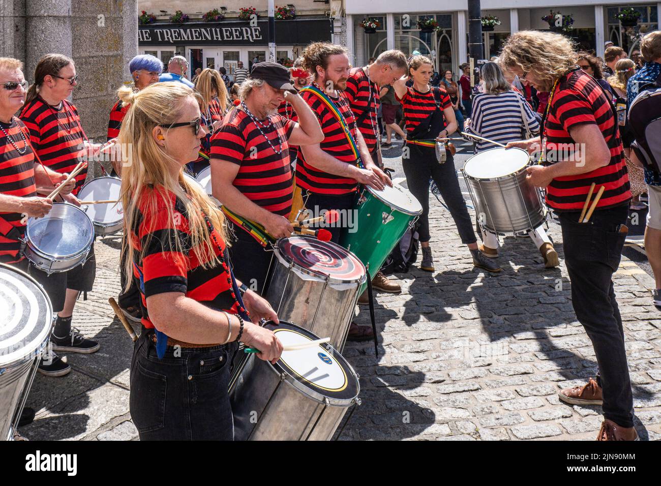 DakaDoum, die Afro/Brasilianische Percussion Band, tritt im Stadtzentrum von Penzance auf, bei der farbenfrohen Mazey Day Prozession in Cornwall in England in Großbritannien. Stockfoto