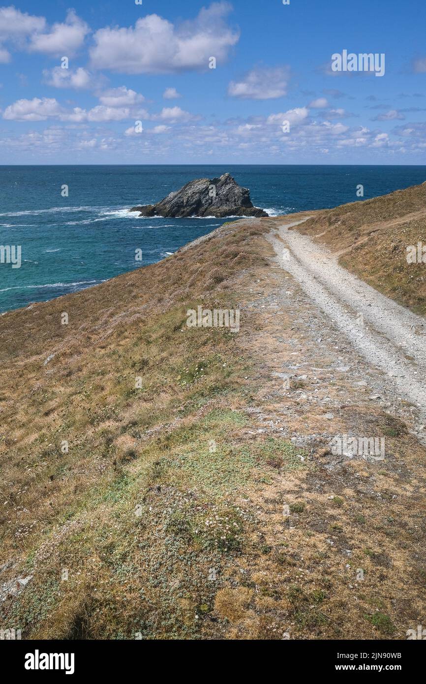 Ein rauer Fußweg, der zu einem Blick auf die felsige Insel The Goose vor der Küste von Pentire Point East in Newquay in Cornwall in Großbritannien führt. Stockfoto