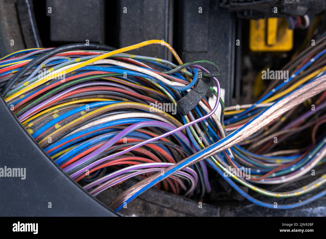 Ein Paket elektrischer Drähte oder Kabel ist stark miteinander verwechselt. Reste von Drähten in verschiedenen Farben. Auf der w befinden sich komprimierte Spitzen Stockfoto