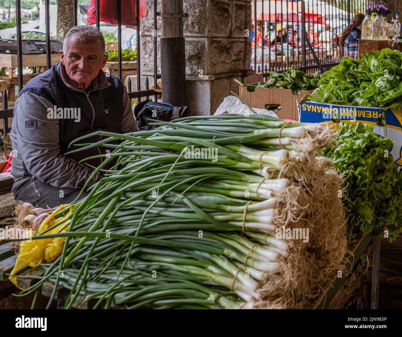 Montenegro - 7. Mai 2022 - der Mann verkauft Gemüse an einem Stand auf dem Markt. Stockfoto