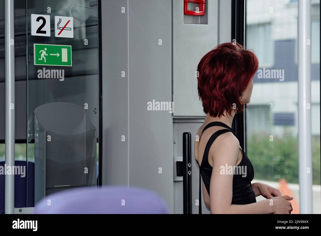 Die junge Frau bereitet sich darauf vor, an einer Haltestelle von einem S-Bahn-Auto auszusteigen Stockfoto