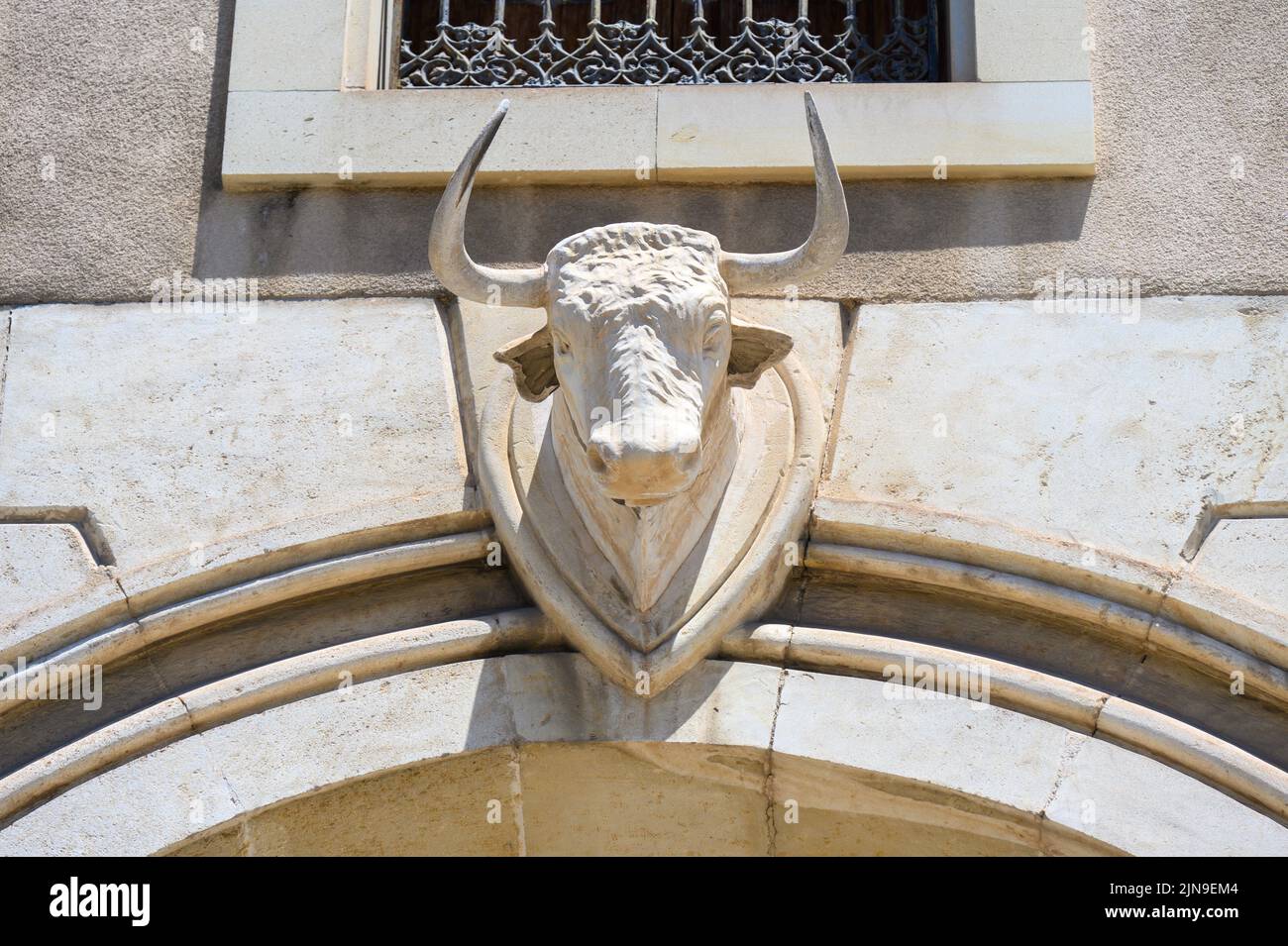 Außenarchitektur des Stierkampfes. Skulptur eines Stiers auf einer Eingangstür. Stockfoto
