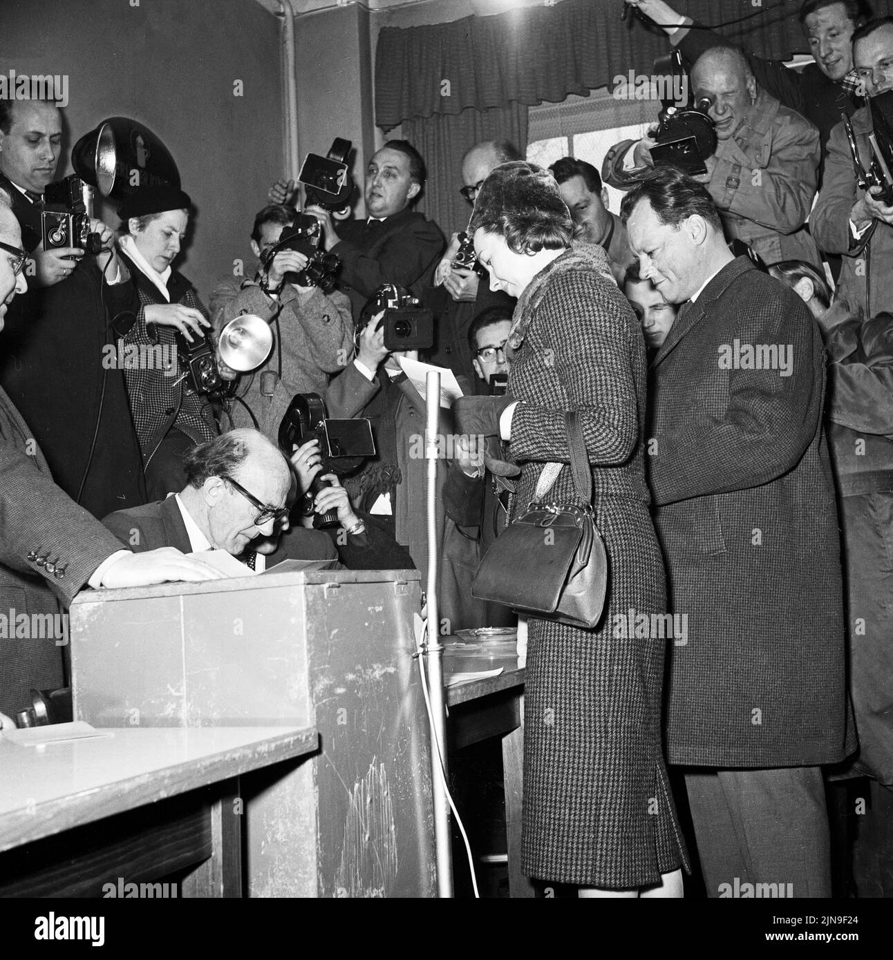 Original-Bildunterschrift: Heute wählt West-Berlin - der Regierende Bürgermeister Willy Brandt mit Frau Rut an der Wahlurne, Berlin, Deutschland 1958. Stockfoto