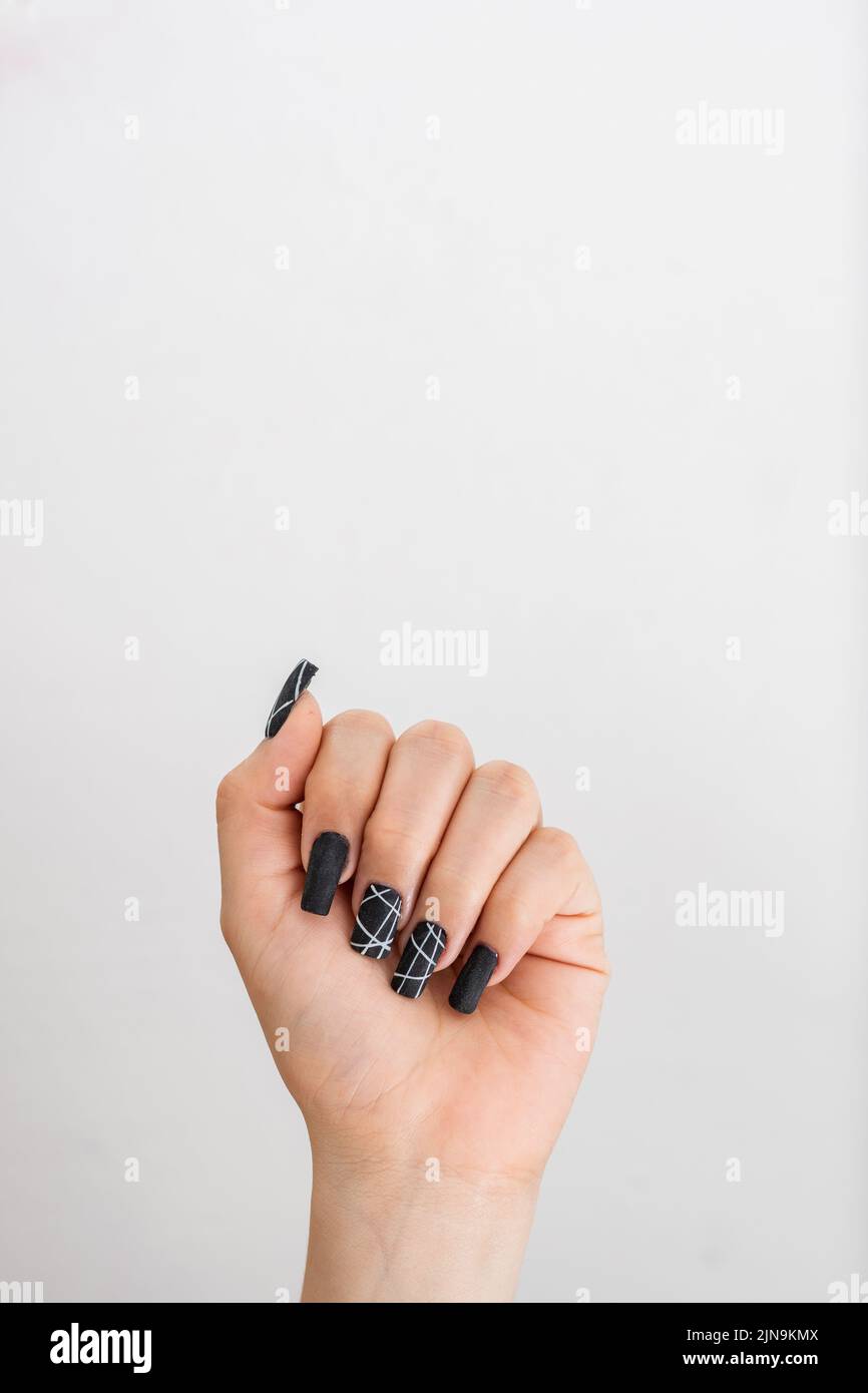 Erhobene Hand eines Mädchens mit schwarz bemalten Fingernägeln, schwingt im Symbol der Stärke, mit Platz oben, um Text zu kopieren. Konzept der Freiheit Stockfoto