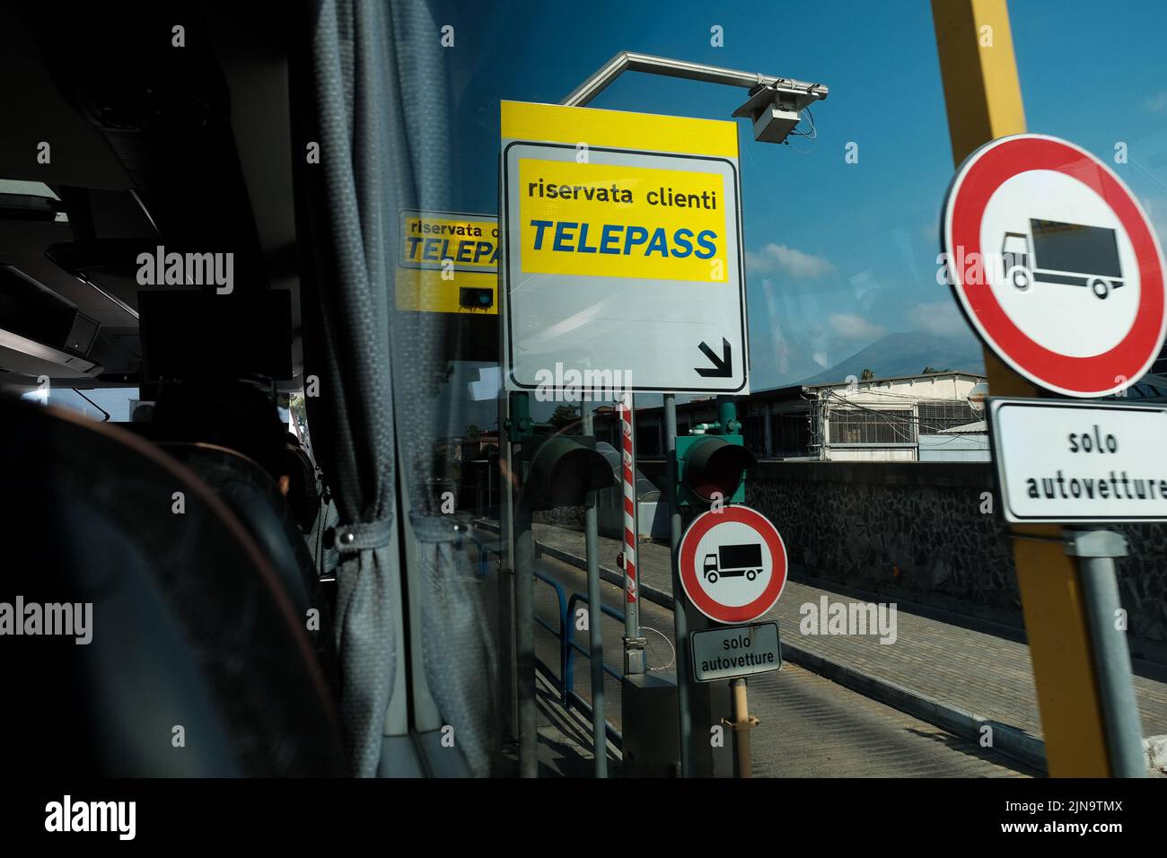 Telepass-Mautschilder, die von einem Busfenster aus durch Italien in der Nähe von Pompeji durchfahren werden. Stockfoto
