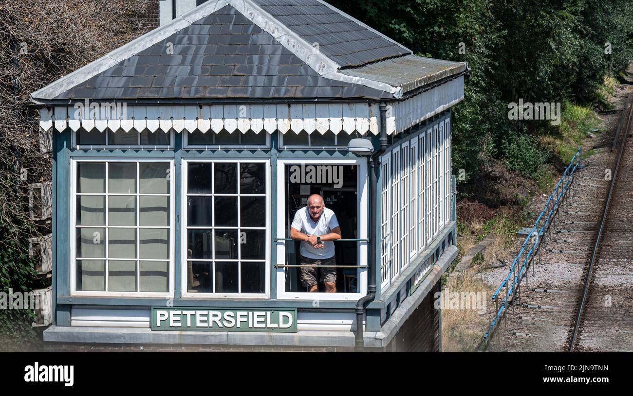 Der Signalmann schaut aus der Signalbox an der Petersfield Station, Hampshire. Stockfoto