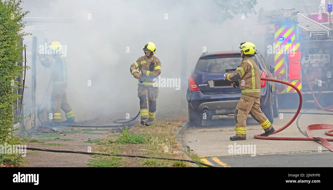 Essex Feuerwehr- und Rettungsdienst Team Arbeitsgruppe Feuerwehrleute in Schutzkleidung arbeiten in gefährlichen und gefährlichen Bedingungen auf Hausbrand England Großbritannien Stockfoto