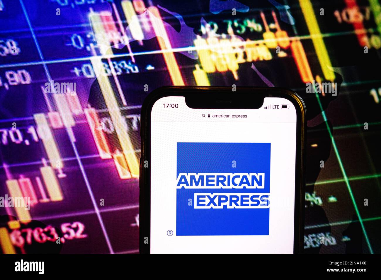 KONSKIE, POLEN – 09. August 2022: Smartphone mit Logo der American Express Gesellschaft im Hintergrund des Börsendiagramms Stockfoto