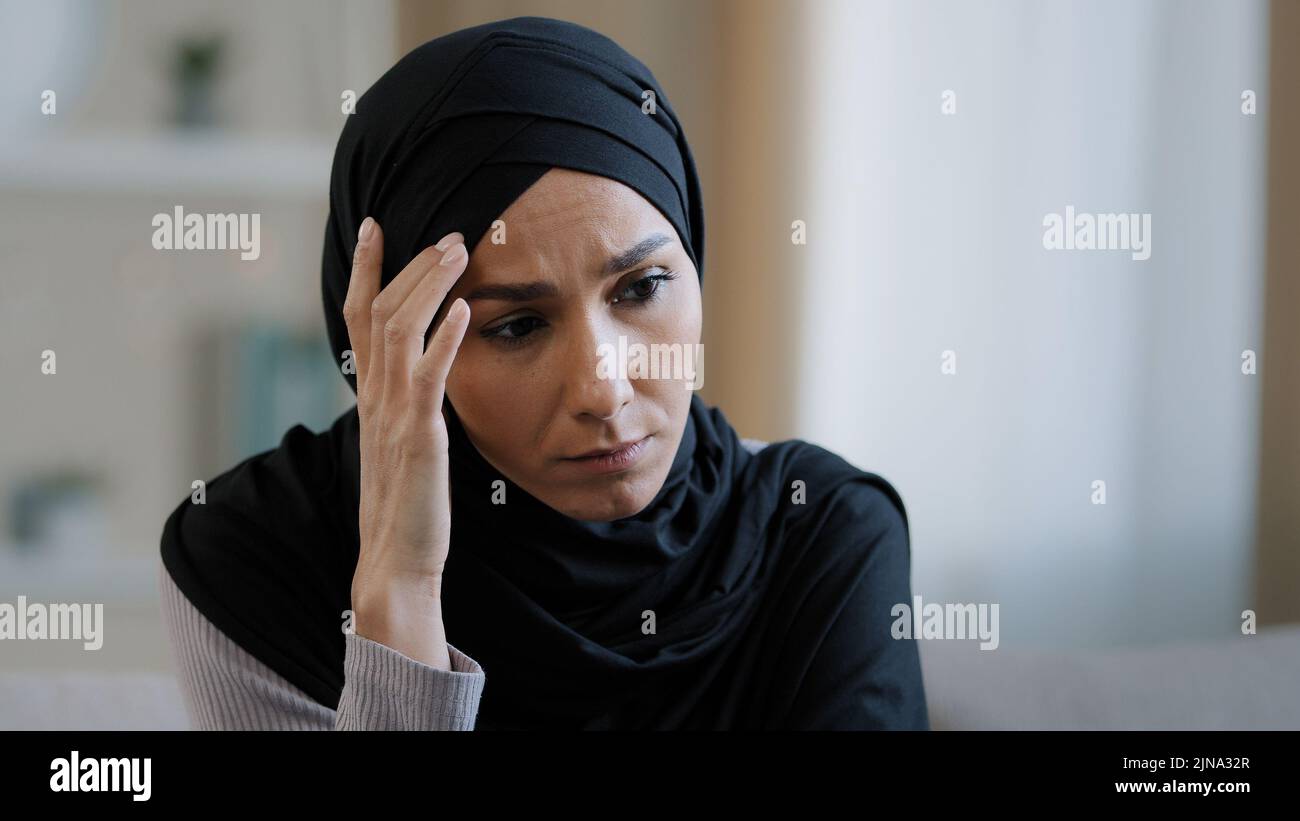 Verärgert traurig Mädchen in Hijab sitzen allein schlechte Nachrichten fühlen sich depressiv frustriert muslimische Frau leiden an Krankheit besorgt über ungelöste Probleme Gefühl Stockfoto