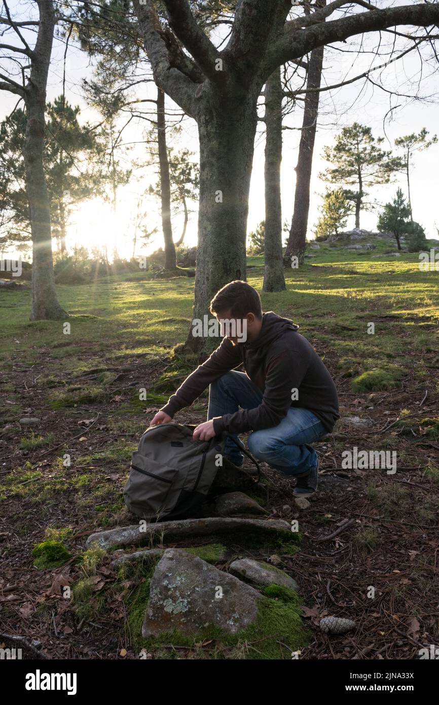 Mann, der seinen Rucksack im Wald öffnet Stockfoto