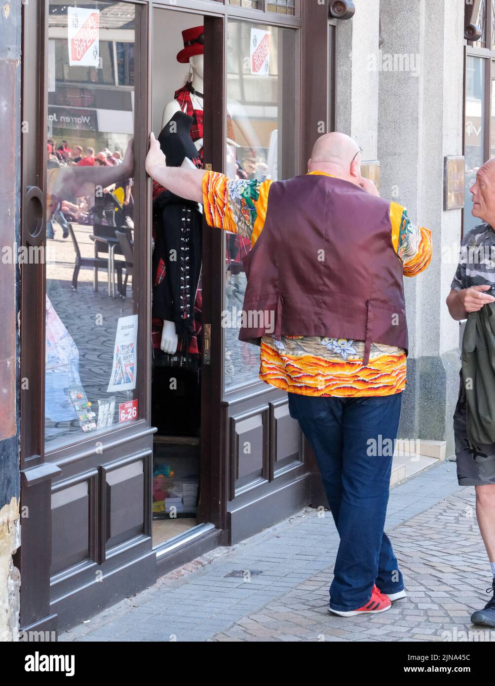 Blackpool, Lancashire, UK August 6 2022 BA Fashion Shop Inhaber in farbenfrohem Kleid steht vor seinem Geschäft während des Blackpool Rebellion Punk Festivals Stockfoto
