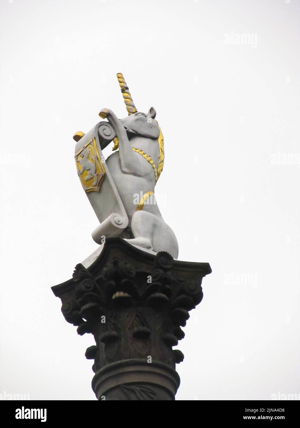 Eine weiß-goldfarbene Statue eines Einhorns auf dem Mercat Cross in Aberdeen, Schottland, gegen einen weißen Himmel. Stockfoto