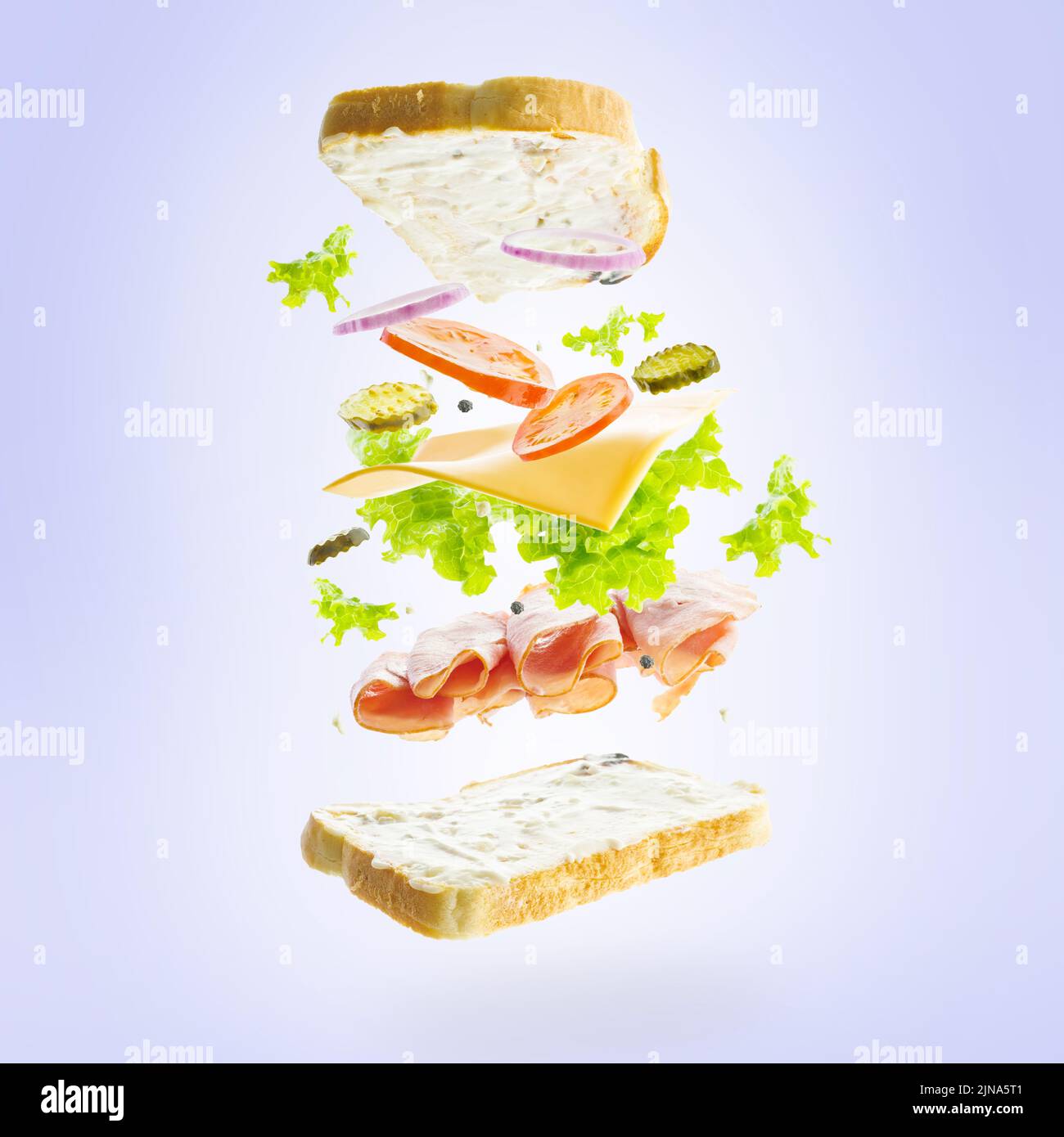 Sandwich auf hellblauem Hintergrund bei gefrorenem Flug. Fleisch, Gemüse, Brotscheiben. Fast Food. Werbung, Banner. Es gibt keine Menschen, die ich bin Stockfoto
