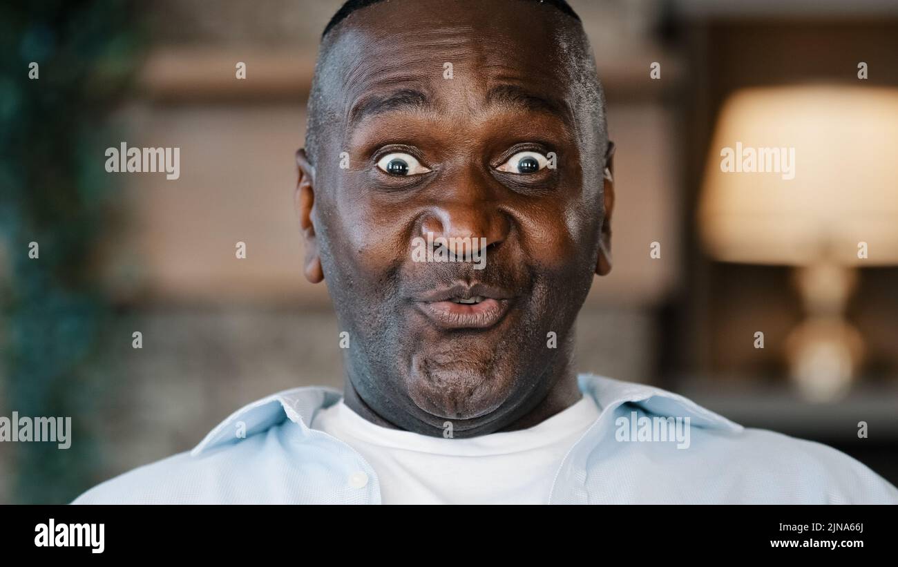 Nahaufnahme überrascht männlichen Porträt erstaunt Gesicht amerikanischen afrikanischen erwachsenen Mann 60s Senior Geschäftsmann Großvater zu Hause stehend fühlen Schock sagen wow Freude Stockfoto